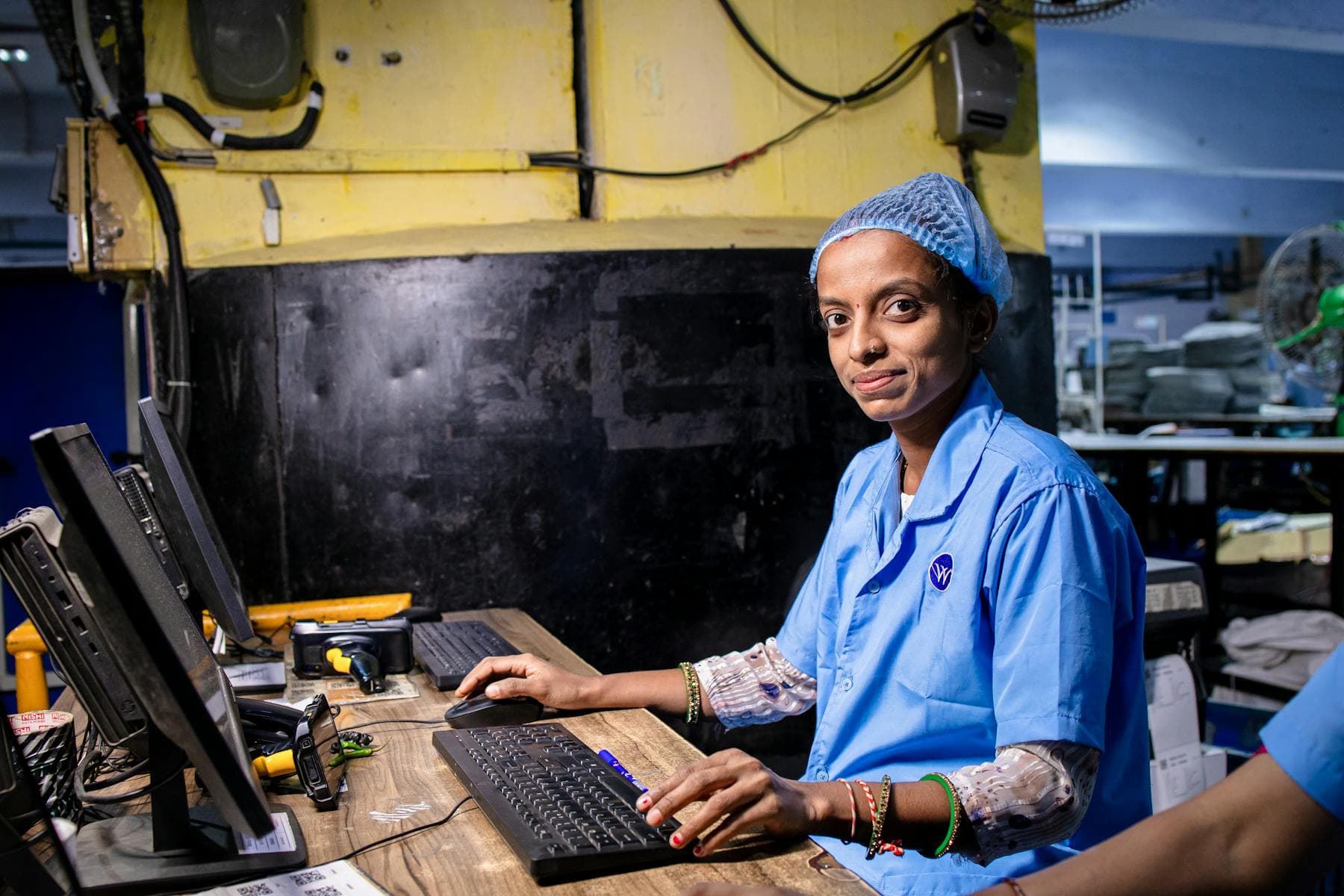 Factory worker operating a computer station in an industrial setting