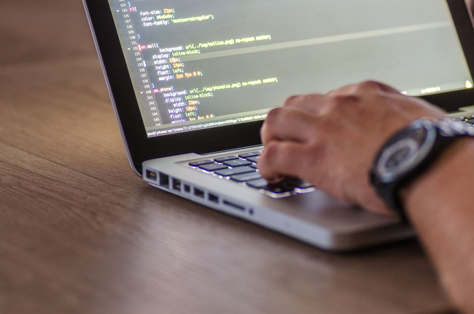 Close-up of person coding on laptop