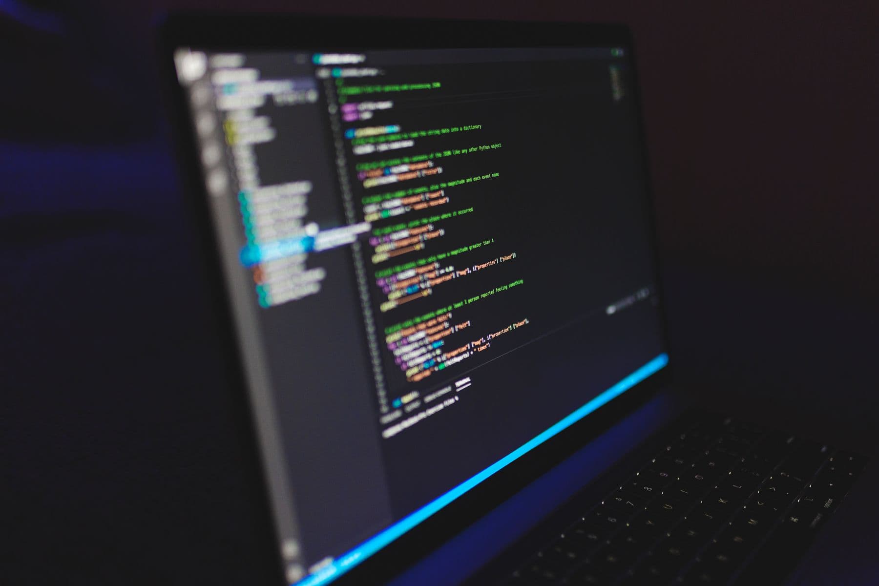 Laptop displaying code in a dark setting